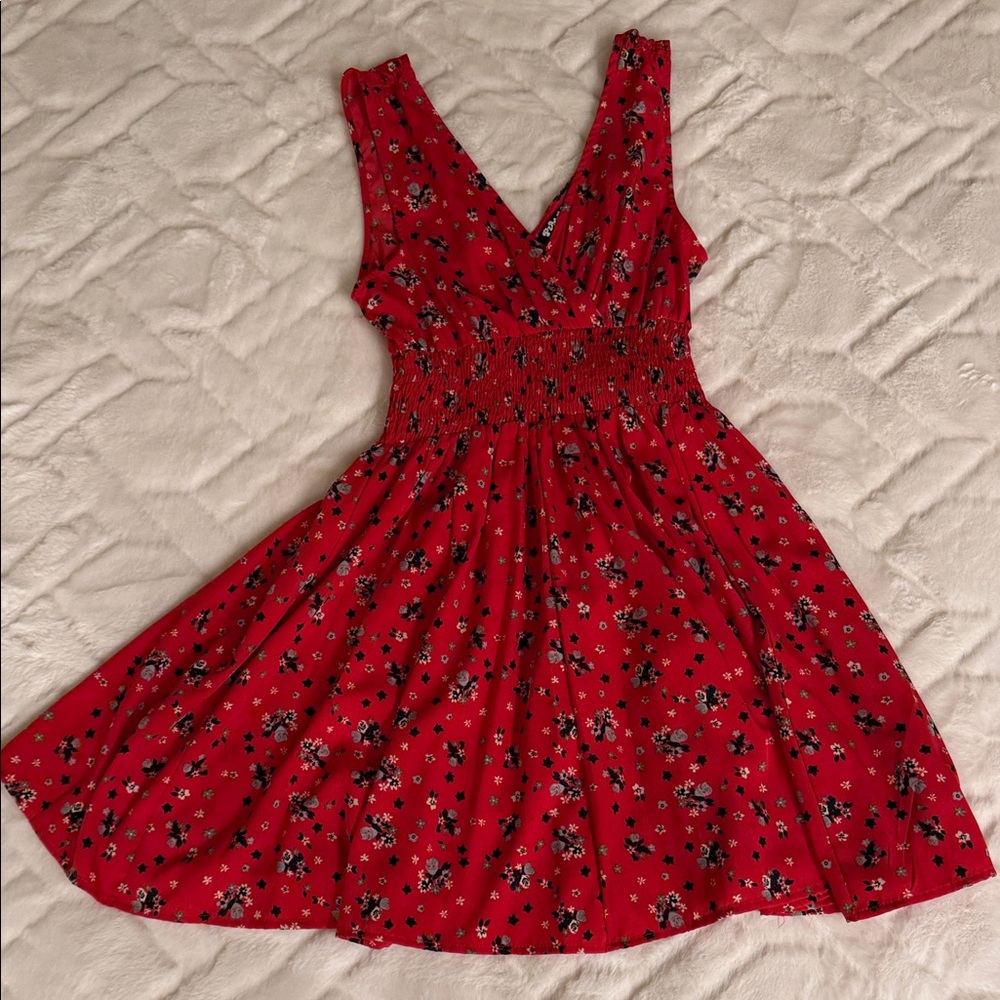 Feminine, flowy, and easy red dress with defined waist band and fine print.